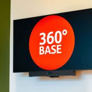 TV-Monitor des Besprechungsraum mit Logo der 360-Grad-Base